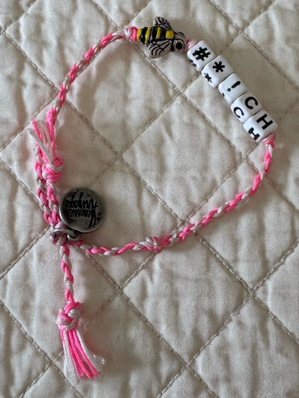 Venessa Arizaga bracelet features a cheeky phrase on white beads and a bee charm